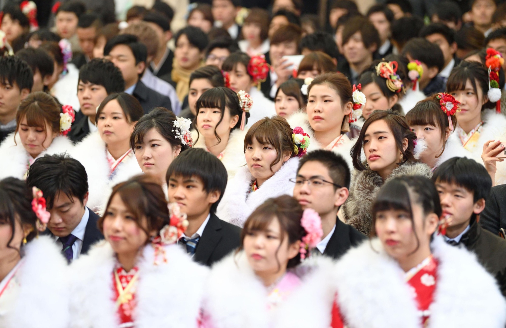 People who turned or were turning 20 attend a Coming-of-Age Day celebration ceremony at Tokyo Disneyland in Urayasu, Chiba Prefecture, on Jan. 8. The Diet on Wednesday enacted a law to lower the age of adulthood to 18 from 20. | KYODO