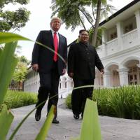 U.S. President Donald Trump and North Korean leader Kim Jong Un walk together after lunch at the Capella Hotel on Sentosa island, Singapore, on Tuesday. | REUTERS