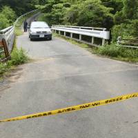 Yellow tape restricts entry to a mountain road Sunday near the site in Fujieda, Shizuoka Prefecture, where a woman\'s body was found a day earlier. | KYODO