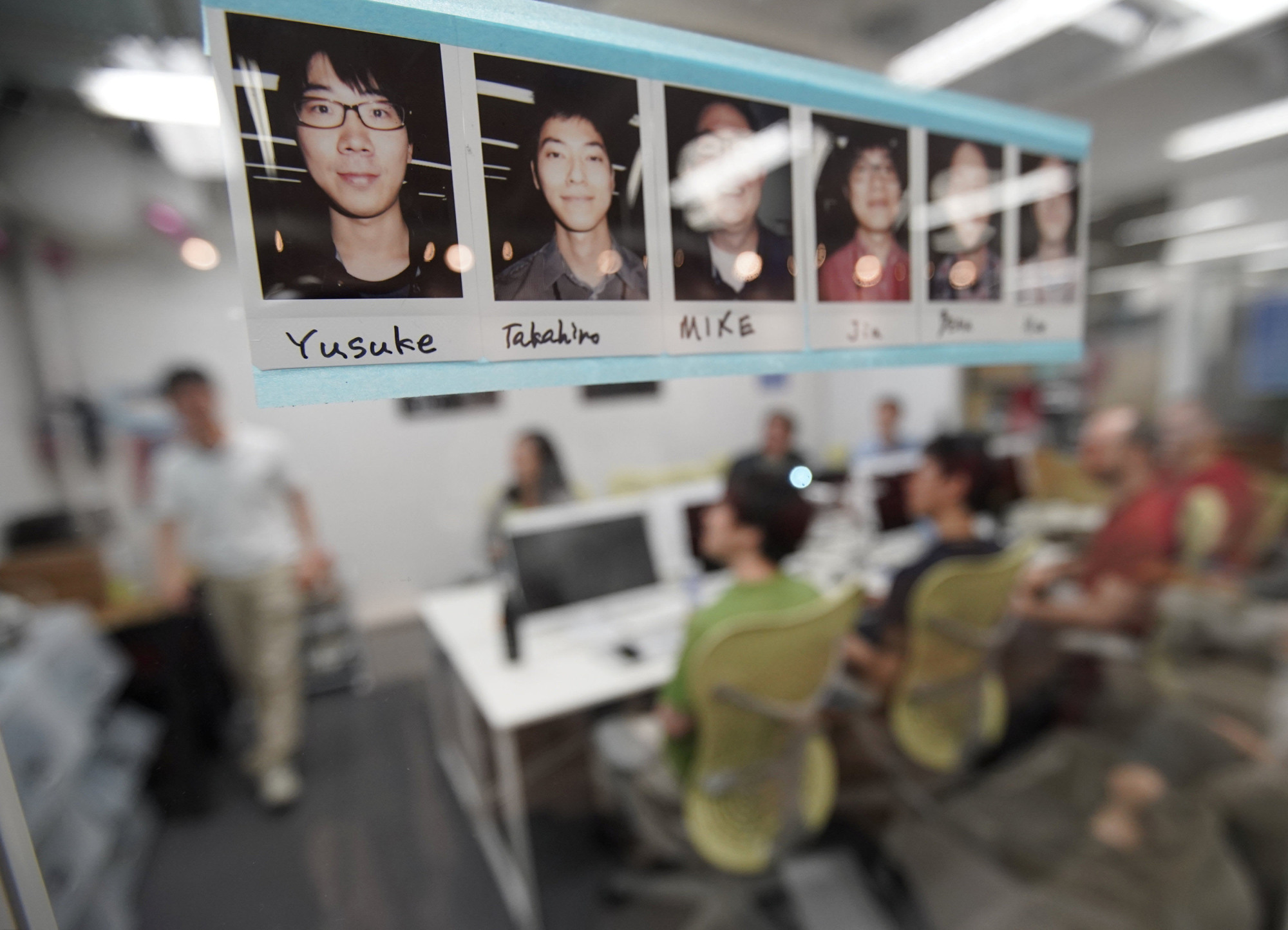 Portraits of students at Code Chrysalis, a software-coding boot camp, are seen on a window of a classroom in a basement room in Tokyo on May 23. | REUTERS