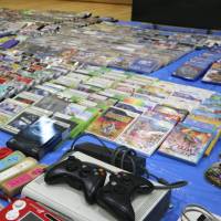 Video game consoles and game titles that police confiscated from bars in Kyoto and Kobe are seen at the Nakagyo Police Station in Kyoto on Wednesday. | KYODO