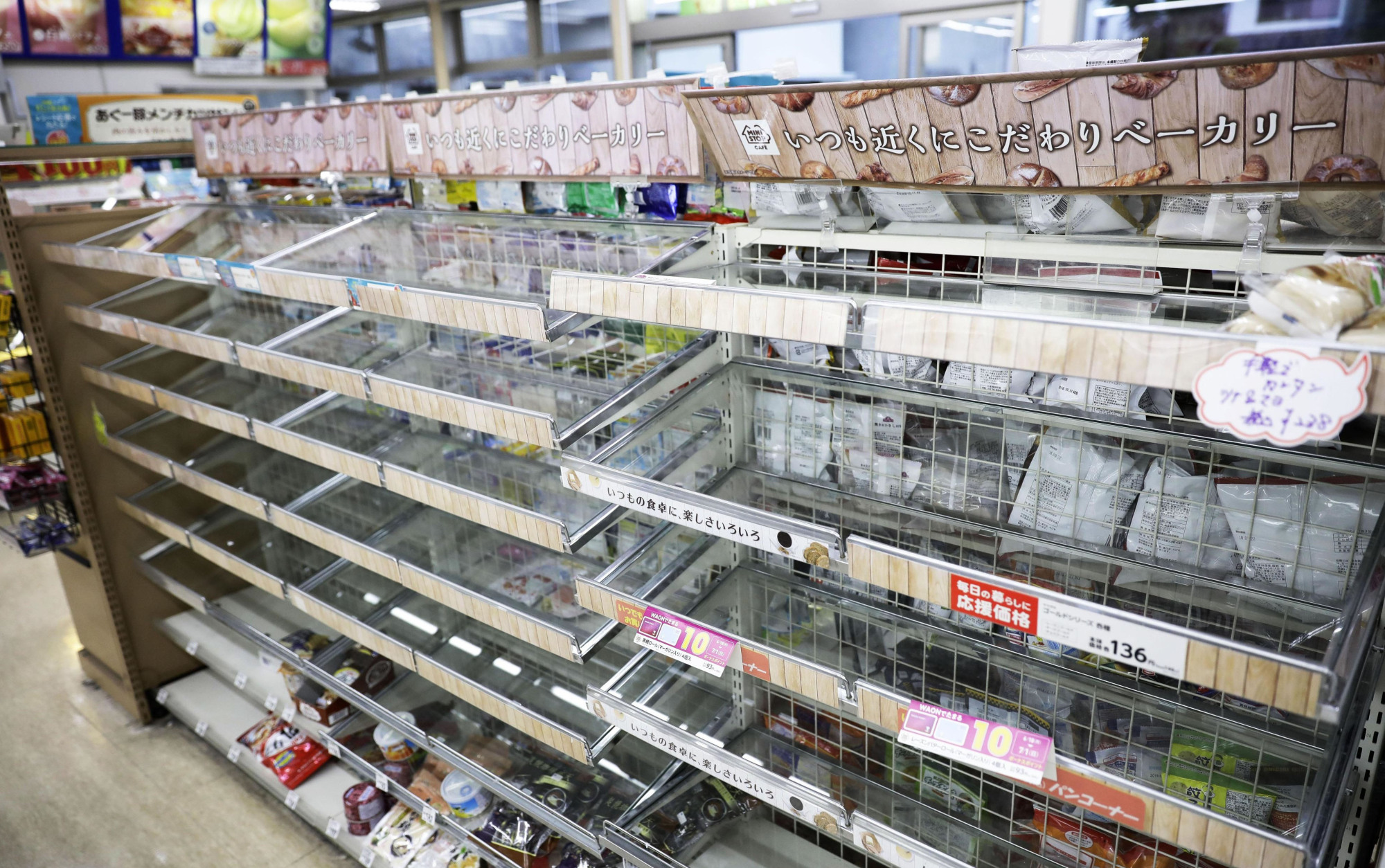 Convenience store shelves are mostly empty on Monday at a convenience store in Ibaraki, Osaka Prefecture, after people flocked to buy food following a strong quake in the area. | KYODO