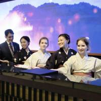 Foreign employees pose at Daiwa Royal Hotel Grande Kyoto, which is set to open Saturday near Kyoto Station. The hotel supports visitors with staff that can speak nine languages. | KYODO