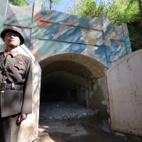 A North Korean soldier stands guard in front of the second tunnel of the hermit nation\'s Punggye-ri nuclear test site in North Hamgyong province before it is blown up on May 24. | REUTERS