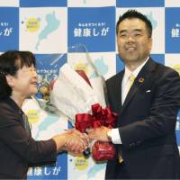 Shiga Gov. Taizo Mikazuki receives a bouquet in Otsu, Shiga Prefecture, on Sunday after he won the gubernatorial election. | KYODO
