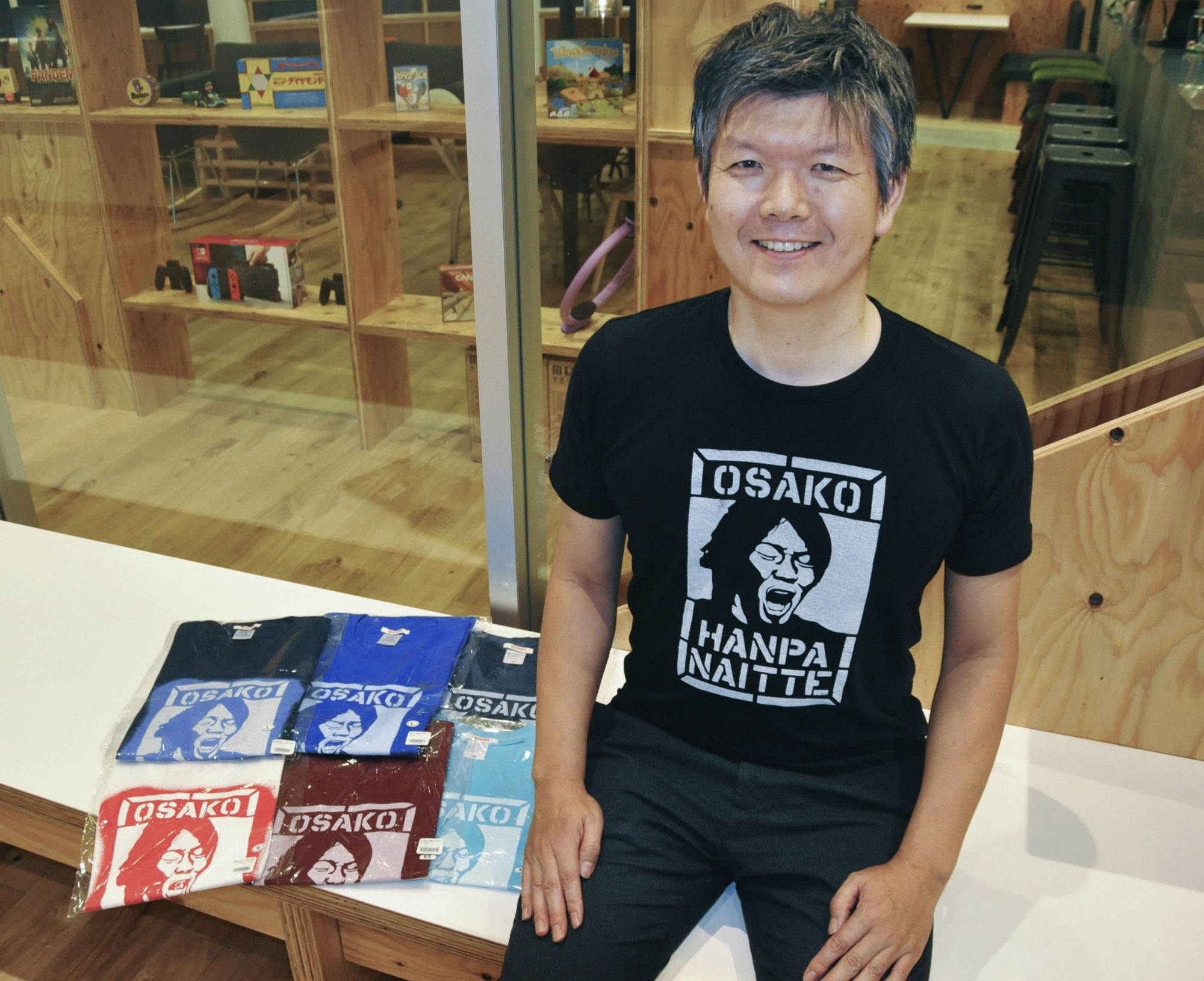 Designer Yasukazu Asano poses with T-shirts he produced with the phrase 'Osako hanpa naitte' ('Osako is way too good') printed on them in May in Tokyo's Chiyoda Ward. | KYODO