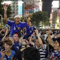 Fans celebrate in Shibuya after Japan beat Colombia in the Group H World Cup soccer match on Tuesday. | AP