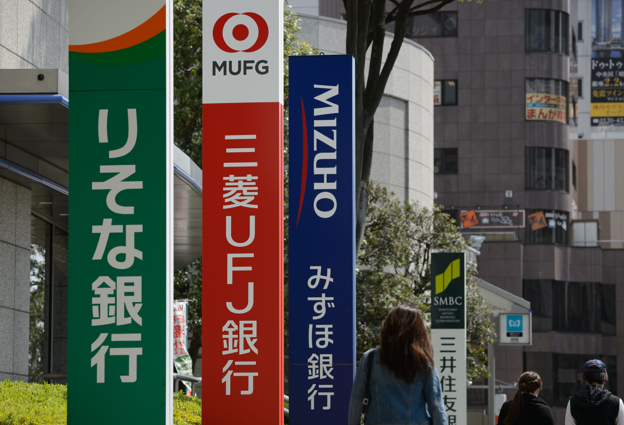 Japanese banks are shifting away from costly ATMs, which are still widespread in the cash-based society. | BLOOMBERG
