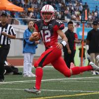 Kyoto University quarterback Daisuke Tanaka carries the ball for Japan during the World University American Football Championship on Saturday in Harbin, China. | KIYOSHI OGAWA