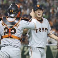 Giants pitcher Shun Yamaguchi (right) celebrates with catcher Seiji Kobayashi after Saturday\'s 7-1 win over the Swallows at Tokyo Dome. | KYODO