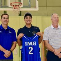 Japanese phenom Chikara Tanaka (center) and IMG Academy officials Chris Ciaccio (right) and Brian Nash pose for photos in Yokohama on Wednesday. | KAZ NAGATSUKA