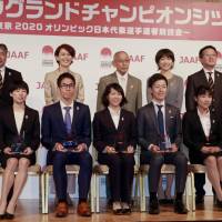 Japanese runners who have earned spots for next year\'s Marathon Grand Championship (ones with the shields), JAAF officials and former Olympic marathoners (in back row) Yuko Arimori, Kenji Kimihara and Naoko Takahashi appear at a Tokyo news conference on Friday. | KAZ NAGATSUKA