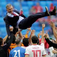 Iran players give Carlos Queiroz a doage as they celebrate their victory over Morocco in the World Cup on Friday night. | REUTERS