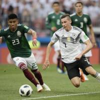 Mexican defender Jesus Gallardo (left) and Germany\'s forward Julian Draxler compete for the ball during the Russia 2018 World Cup Group F football match between Germany and Mexico at the Luzhniki Stadium in Moscow on Sunday. Mexico won the match 1-0. | JUAN MABROMATA / VIA AFP-JIJI