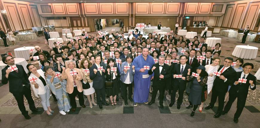 Georgian ozeki Tochinoshin (center) and Tsintsadze pose for a photo during a reception to celebrate the anniversary at the Imperial Hotel on May 25.