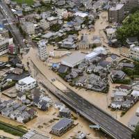 Roads are flooded with heavy rain in Asakita Ward in the city of Hiroshima on Saturday morning. | KYODO