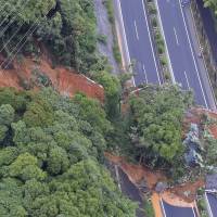 Roads are cut off by a mudslide at a section of the Kyushu Expressway in Kitakyushu, Fukuoka Prefecture, Saturday morning. | KYODO