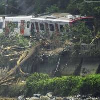 A train sits derailed on a section of the JR Chikuhi Line in Karatsu, Saga Prefecture, Saturday morning after a landslide hit the tracks. | KYODO