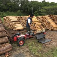 Naoto Akagi, president of Ashitaka, uses a machine to cut firewood. | MAIKO MURAOKA