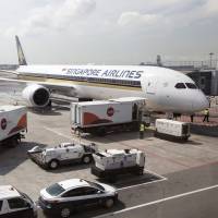 A Boeing Co. 787-10 Dreamliner run by Singapore Airlines Ltd. is linked to a passenger boarding bridge at Changi Airport in Singapore, on March 28. Travelers voted Singapore Airlines the best carrier in the world, according to SkyTrax. | BLOOMBERG