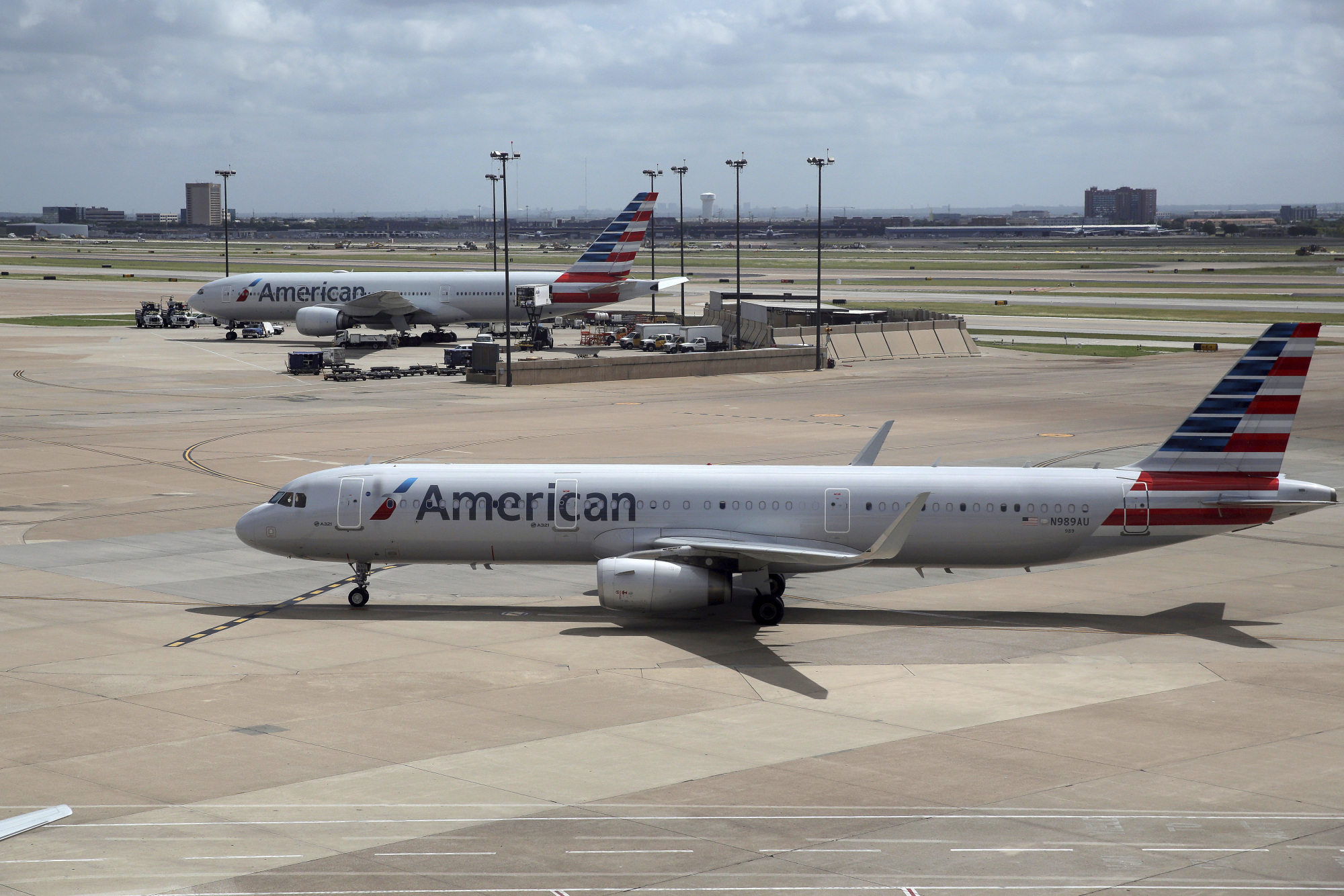 American Airlines aircraft are seen at Dallas-Fort Worth International Airport in Grapevine, Texas, June 16. American Airlines says it will stop using plastic straws and drink stirs and replace them with biodegradable alternatives. American said Tuesday that starting this month in its airport lounges it will serve drinks with straw and wood stir sticks and begin moving to what it called eco-friendly flatware. | AP