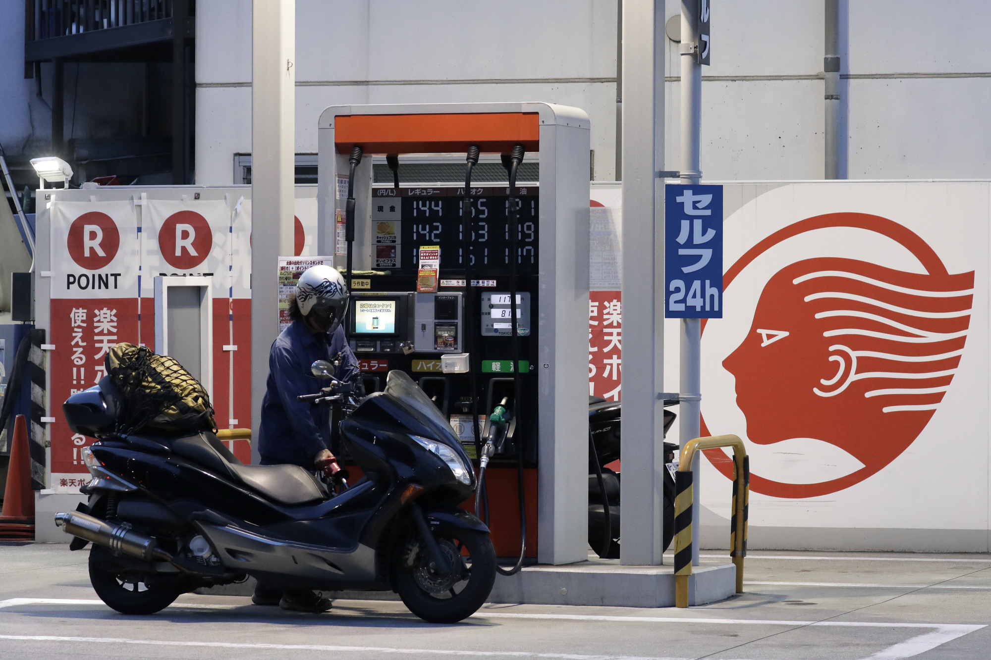 A customer refuels a motorbike at an Idemitsu Kosan Co. gas station in Tokyo. Investor Yoshiaki Murakami played a key role in advising a merger between Idemitsu and Showa Shell Sekiyu K.K. | BLOOMBERG