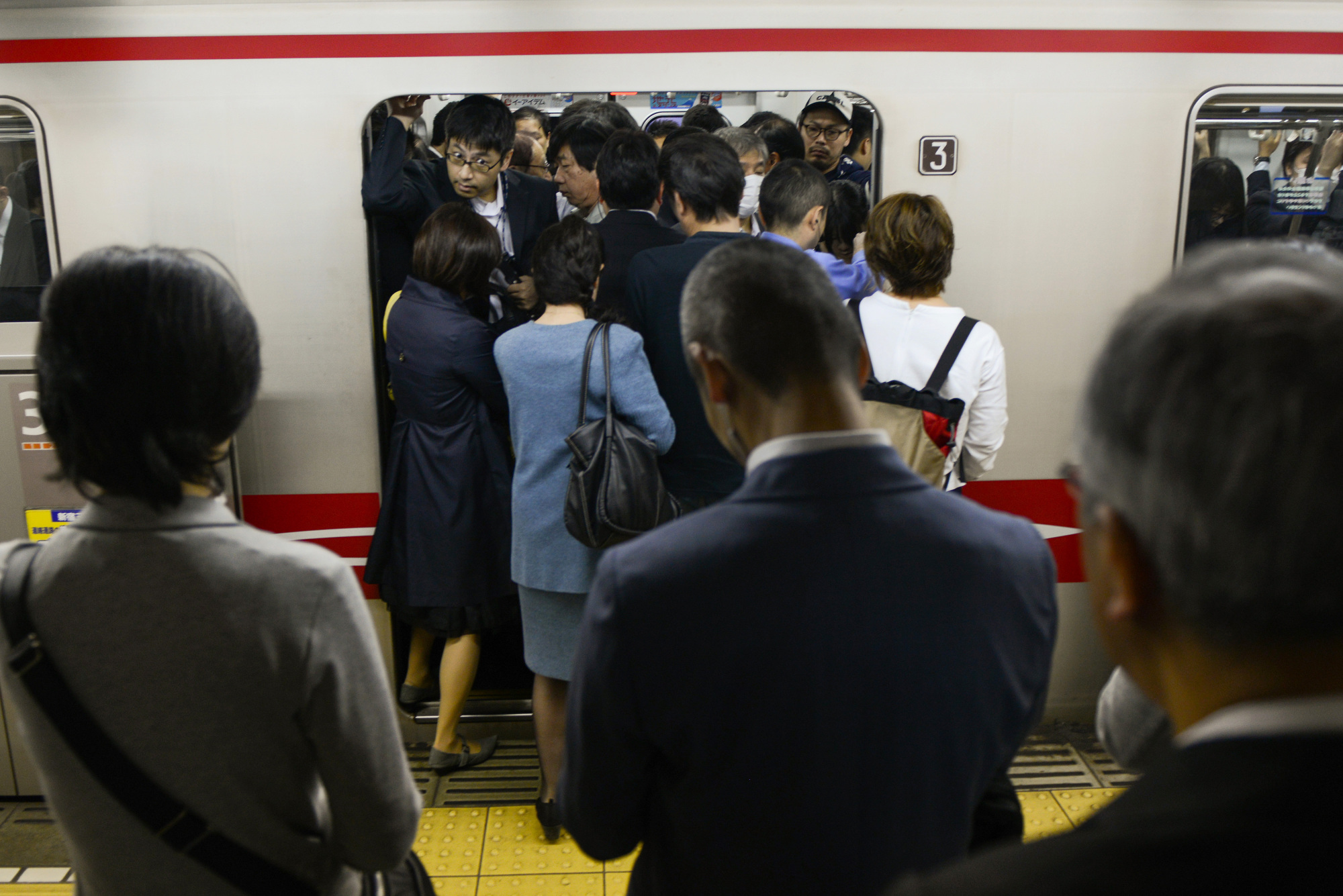 Passengers board a train on the Marunouchi Line. Tokyo launched the Jisa Biz campaign July 9 in a bid to combat jam-packed trains during rush hour. About 740 companies are participating. | BLOOMBERG