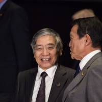 Bank of Japan Gov. Haruhiko Kuroda (left) chats with Finance Minister Taro Aso, who also holds the deputy prime minister portfolio, while attending the Group of 20 meetings of finance ministers and central bankers in Buenos Aires on Saturday. | BLOOMBERG