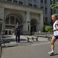 A jogger passes by the Finance Ministry in central Tokyo. The scandal-hit ministry has named its new top bureaucrat and tax collecting chief, months after a string of resignations over scandals. | BLOOMBERG