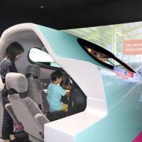 Visitors experience a train driving simulator for the E-5 series Hayabusa shinkansen at the new annex building of the Railway Museum in Saitama city on Thursday. | KYODO