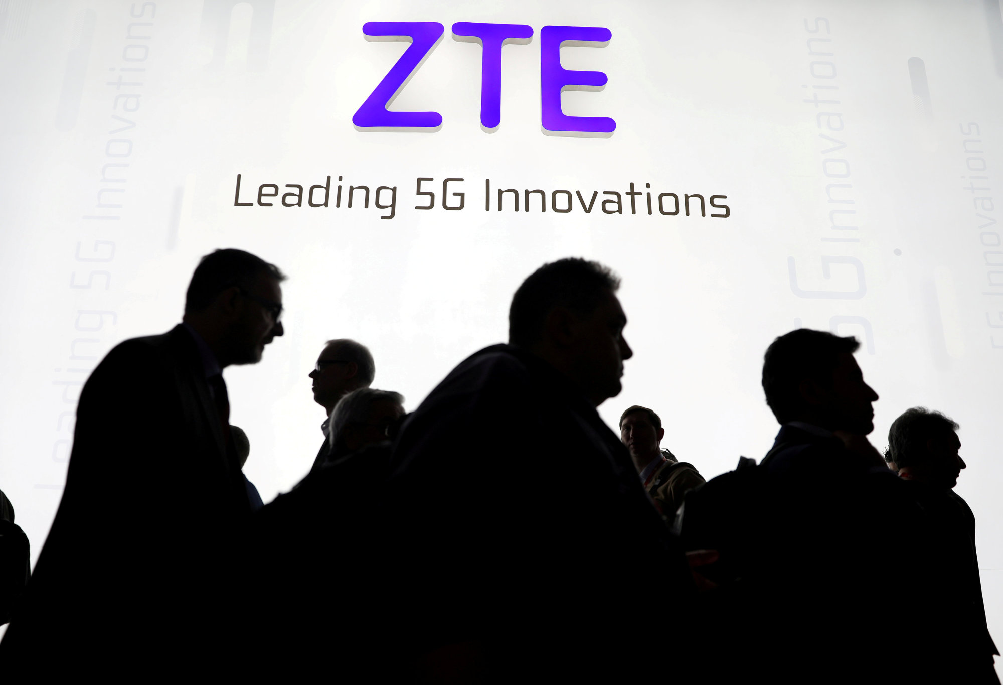 Visitors pass in front of the Chinese telecoms equipment group ZTE Corp. booth at the Mobile World Congress in Barcelona, Spain, in February. | REUTERS