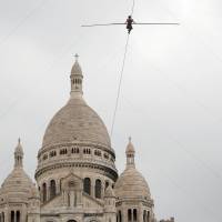 Tatian-Mosio Bongonga advances on a tightrope as she scales the Monmartre hill towards the Sacre Coeur Basilica in Paris on Saturday. | REUTERS