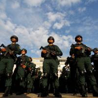 Cambodian police display riot gear and assault rifles on Wednesday at the Olympic stadium in Phnom Penh ahead of a general election this weekend. | REUTERS