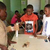 Children conduct an experiment using a model hand made out of cardboard and string at the NextGen Technology Center in Yaounde, Cameroon, on July 11. | THOMSON REUTERS FOUNDATION / INNA LAZAREVA
