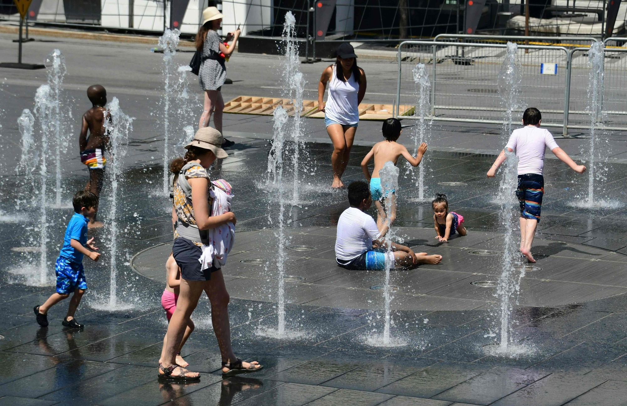 Women and children play in the water fountains at the Place des Arts in Montreal Tuesdayon a hot summer day. A heatwave in Quebec has killed at least 17 people in the past week as high summer temperatures scorched eastern Canada, health officials said on Wednesday. Twelve of the dead were reported in the eastern province's capital Montreal, said regional public health director Mylene Drouin. | AFP-JIJI