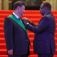 Chinese President Xi Jinping receives a decoration from Senegalese President Macky Sall at the Palace of the Republic in Dakar on Saturday. | AFP-JIJI