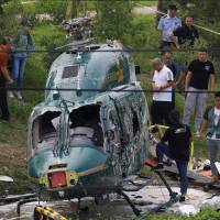 Rescue workers and investigators work at the site of a helicopter crash in Beijing on Monday. | REUTERS