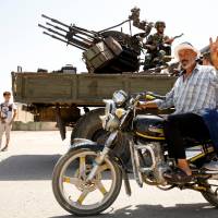 A man gestures as he rides a motorbike in Deraa, Syria, Wednesday. | REUTERS
