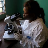 A laboratory worker uses a microscope at the health center in the commune of Wangata during a vaccination campaign against the outbreak of Ebola in Congo on May 23. | REUTERS