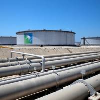 Aramco tanks and oil pipes are seen at Saudi Aramco\'s Ras Tanura oil refinery and oil terminal in Saudi Arabia in May. | REUTERS