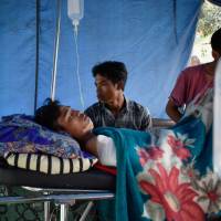 An earthquake survivor receives medical treatment at a temporary shelter in Lombok, Indonesia, on Sunday. | AFP-JIJI