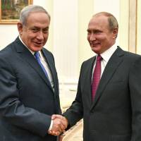 Russian President Vladimir Putin (right) greets Israeli Prime Minister Benjamin Netanyahu during their meeting at the Kremlin in Moscow Wednesday. | YURI KADOBNOV / POOL PHOTO / VIA AP
