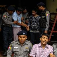 Detained Myanmar journalists Kyaw Soe Oo (front, center) and Wa Lone (back, second right) are escorted by police from a courthouse following their ongoing pretrial hearing in Yangon on July 9. | AFP-JIJI