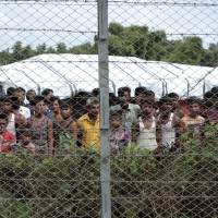 Rohingya refugees gather near a fence during a government organized media tour to a no-man\'s land between Myanmar and Bangladesh, near Taungpyolatyar village, Maung Daw, northern Rakhine State, Myanmar, Friday. | AP