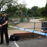A police officer stands at a cordon at Queen Elizabeth Gardens in Salisbury, southern England, Wednesday. The area is believed to be cordoned off in relation to a major incident declared after two people were found unconcious at a residence in nearby Amesbury. | AFP-JIJI