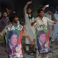 Supporters of Imran Khan, head of the Tehreek-e-Insaf (Movement for Justice) party, celebrate in Islamabad on Wednesday night. | AFP-JIJI