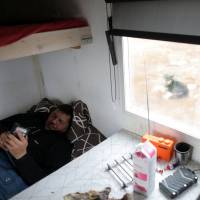 Sami reindeer herder Nils Mathis Sara, 60, takes a rest inside a small cabin near Lake Iesjavri, in the Finnmark Plateau in Norway on June 15. | REUTERS