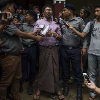 Detained Myanmar journalist Wa Lone speaks to reporters during a break in his ongoing trial at a court in Yangon on July 2, for the final arguments on pretrial hearings. | AFP-JIJI