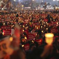 South Korean protesters hold up candles during a rally calling for South Korean President Park Geun-hye to step down in Seoul on Nov. 19, 2016. | AP
