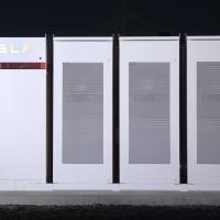 Tesla Inc. Powerpacks that will be used to form the world\'s largest lithium-ion battery stand on display at the Hornsdale wind farm near Jamestown, South Australia, on Sept. 29, 2017. | BLOOMBERG